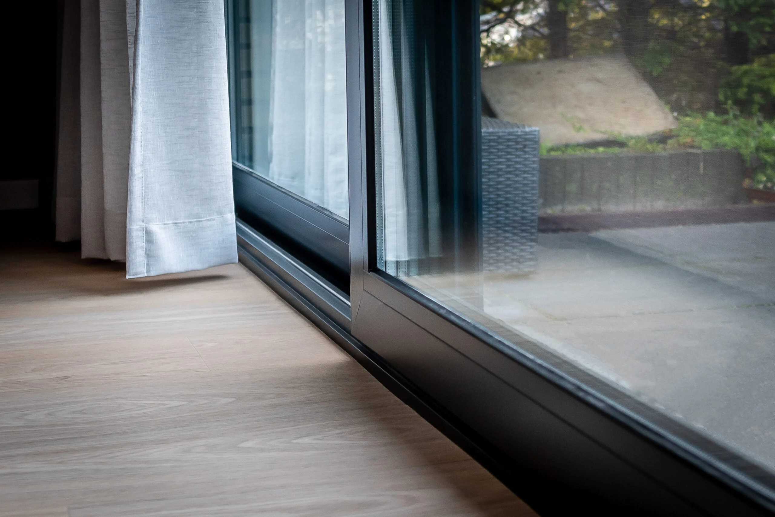 Close-up van aluminium Reynaers CP130 schuifpui met vlakke dorpel en aansluiting op houten vloer – Toelevering Online